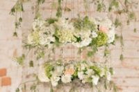 three tier whimsical hanging floral chadelier that consists of blush, ivory, and green blooms