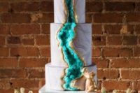 02 stunning turquoise geode wedding cake with gold rim and animal toppers