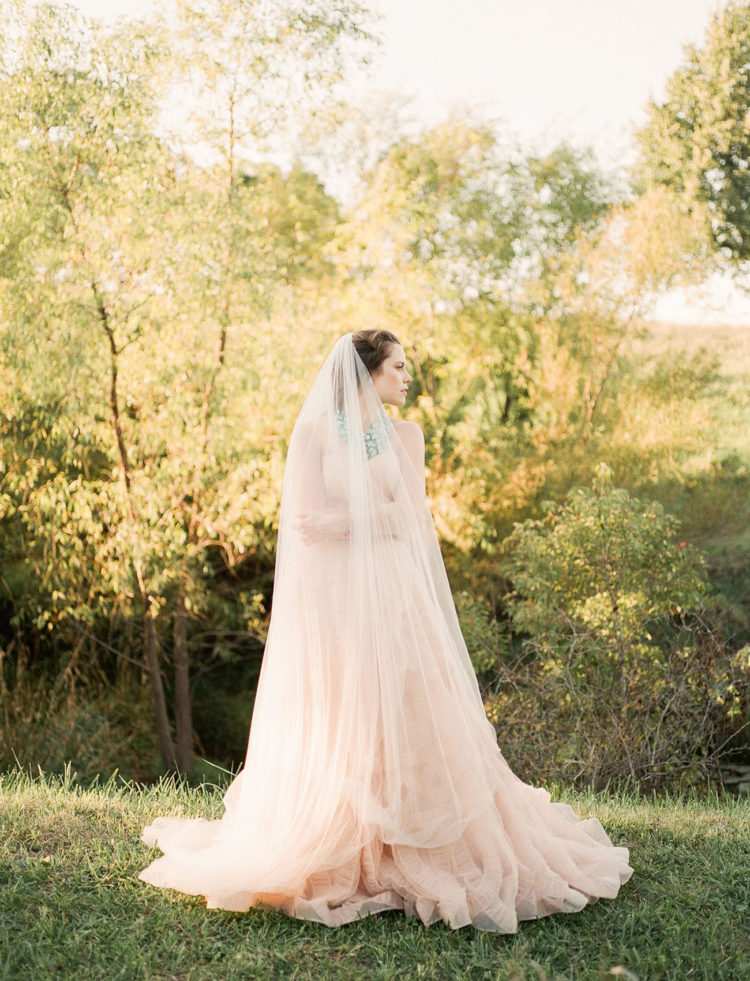 The bride was wearing a gorgeous wedding gown in blush and a matching veil, both with texture