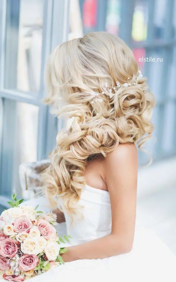 blonde side-swept curls with a beaded hairpiece and a lot of volume will perfectly finish off any formal bridal look with a touch of glam