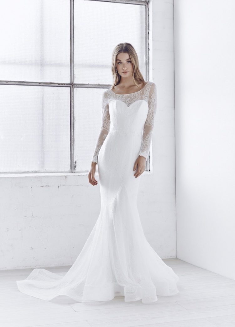 With an elegant illusion neckline, long sleeves, and fitted trumpet skirt in delicate ivory lace, the soft, ethereal elegance of the Milla Dress is both sexy and sweet