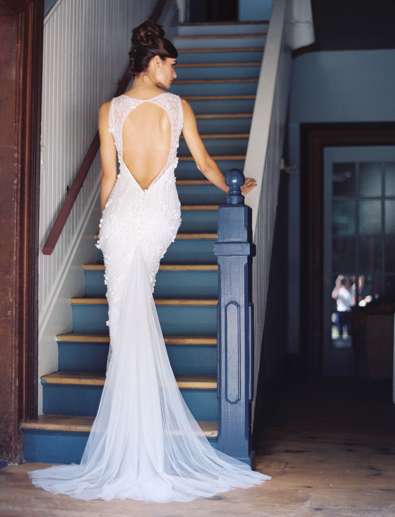 A back cutout and darling beaded detail, plus the flowing train make this gown stunning