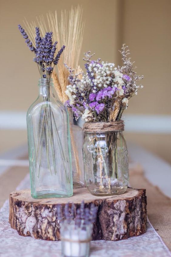 a log slice with lavender, spikes and flowers in jars make a cute centerpiece
