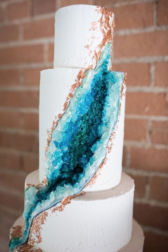 stunning white wedding cake with blue geodes and copper edges