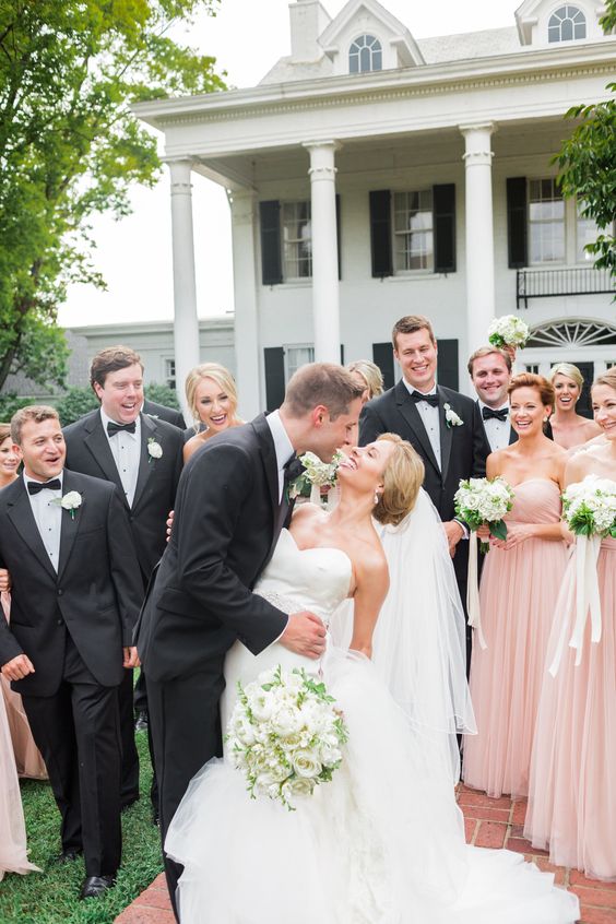 groomsmen in black tuxedos and bridesmaids in blush gowns