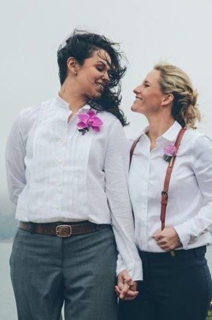 both brides in pants, white shirts, suspenders and tropical flower boutonnieres