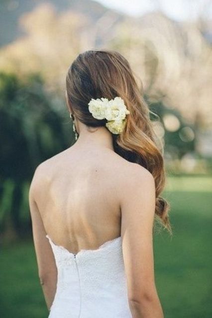 side swept hair with small fresh flowers to highlight it