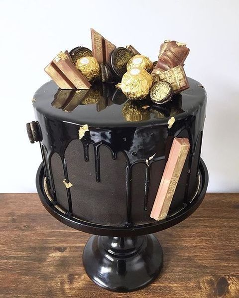 dark chocolate cake with dripping and gilded oreos and chocolate candies looks very elegant