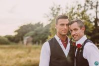 15 grooms wearing the same shirts and vests, red roses for boutonnieres