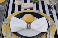 18 a black and white tablescape with bold yellow fabric placemats and lemons