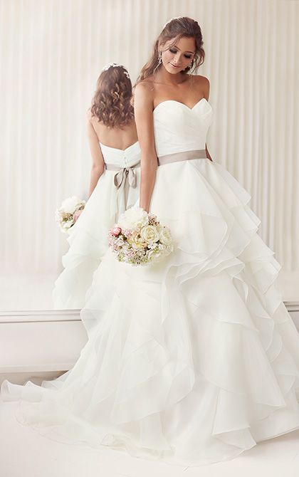 an asymmetrical ruched bodice, and billowing layers of organza and a grey sash