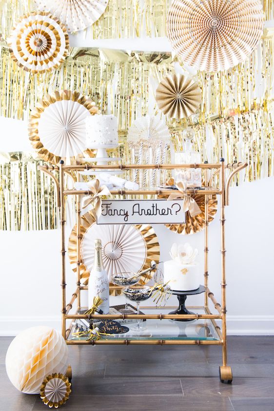fringe backdrop and paper fans with metallic touches