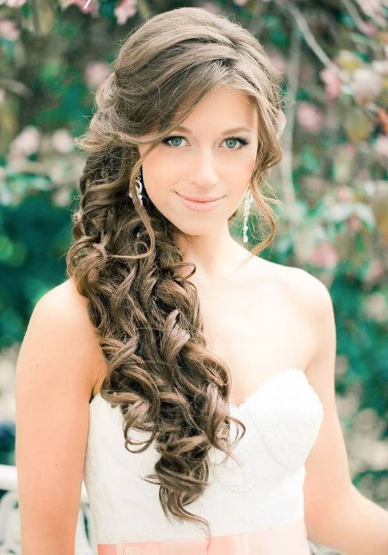 a side-swept ponytail with side bangs and waves down plus a lot of volume looks formal and glam
