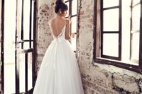 22 a spaghetti strap dress with an open back, a bow on the back and lace decor on the tulle skirt