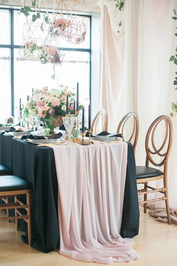 blush and black table setting with black candles and ivory and pink flowers