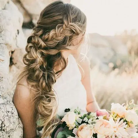 a huge voluminous side-swept braid will be a gorgeous idea for a boho bride, it looks stylish and chic
