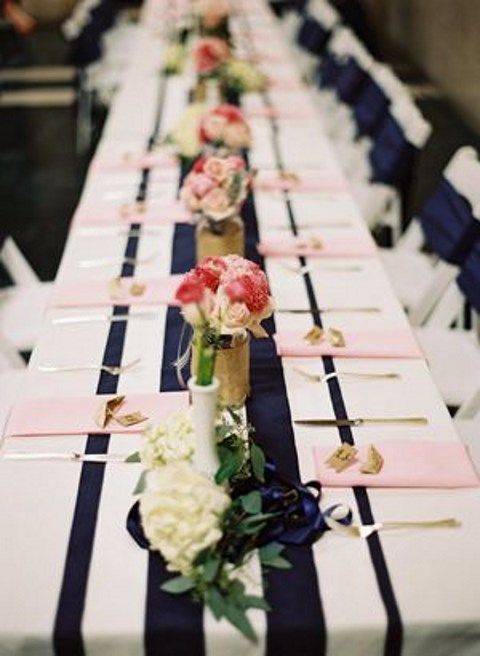 a striped navy table runner and blush napkins