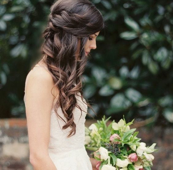 brunette side-swept hair with a braided touch, waves down, a bump on top is a cool idea for a romantic and relaxed bride
