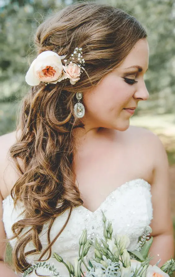 curly side-swept hair can be beautifully accentuated with fresh flowers, and this hairstyle is easy to repeat