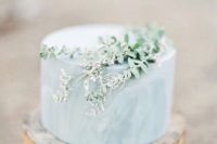 27 slate blue one-tier marble cake topped with fresh greenery