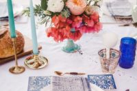 30 a Mediterrnean table setting with an azulejo tile placemat, blue candles and colored florals