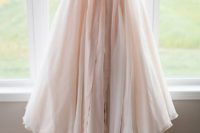 34 blush lace wedding dress with a flowy skirt and a bow