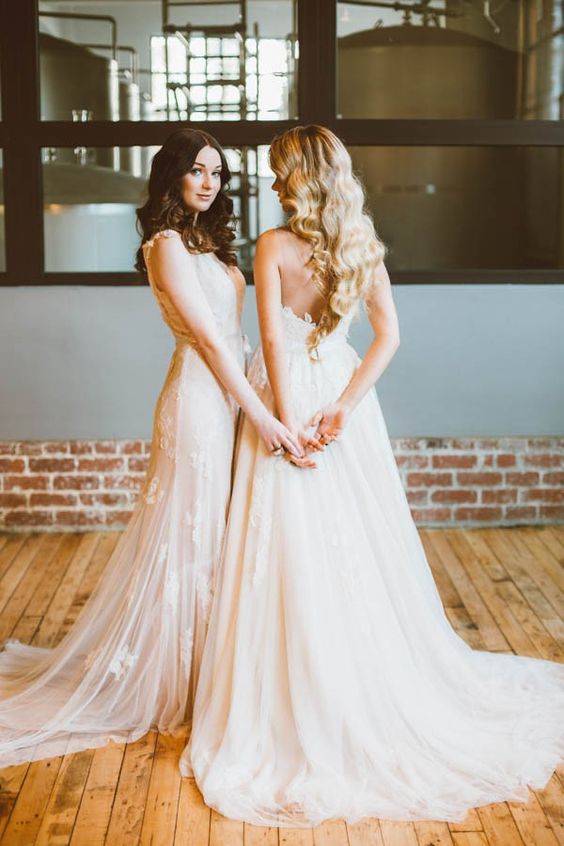 a strapless ivory wedding dress and a blush lace applique wedding gown create a very romantic and delicate couple look