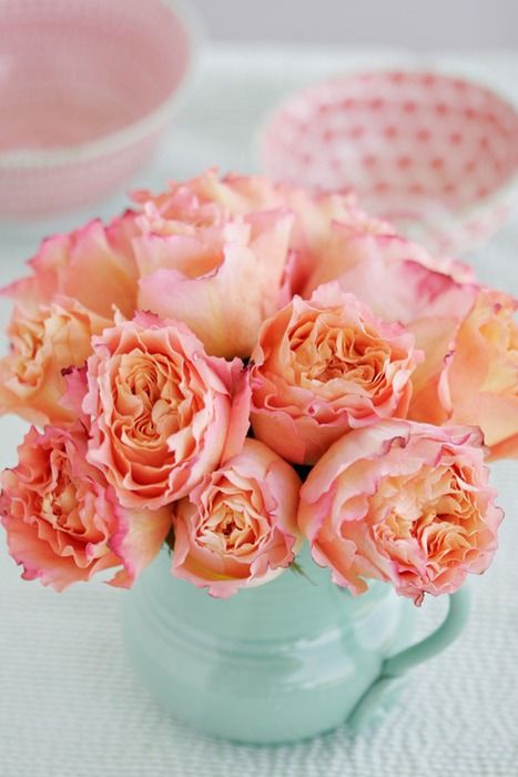 peach and pink roses in a mint pitcher