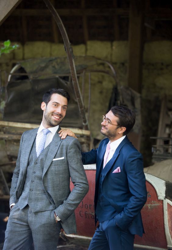 a tweed grey suit for one groom, a bold blue with blush touches for the second