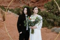 a black pantsuit, a white shirt and a black tie, brown shoes, a romantic plain wedding dress with long sleeves for a desert wedding