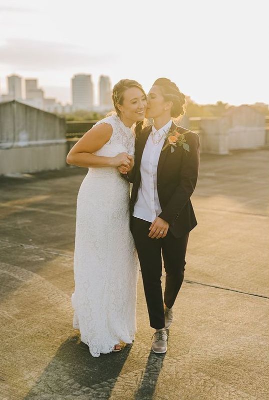 a black pantsuit, a white shirt, grey shoes and necklaces, a boho lace sleeveless A-line wedding dress are a great combo