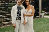 a boho lace strapless mermaid wedding dress with a train, a white pantsuit, a dark floral shirt and silver shoes