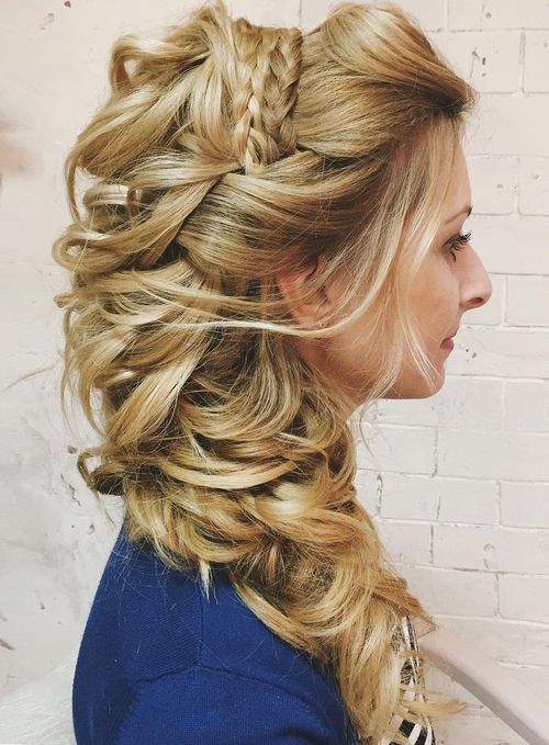 a complicated side swept hairstyle with waves and braids on top, with a huge loose wavy ponytail on one side
