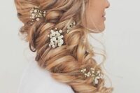 a dimensional curled blonde side braid with a side braided halo and baby’s breath is a cool and chic idea for a boho or rustic wedding