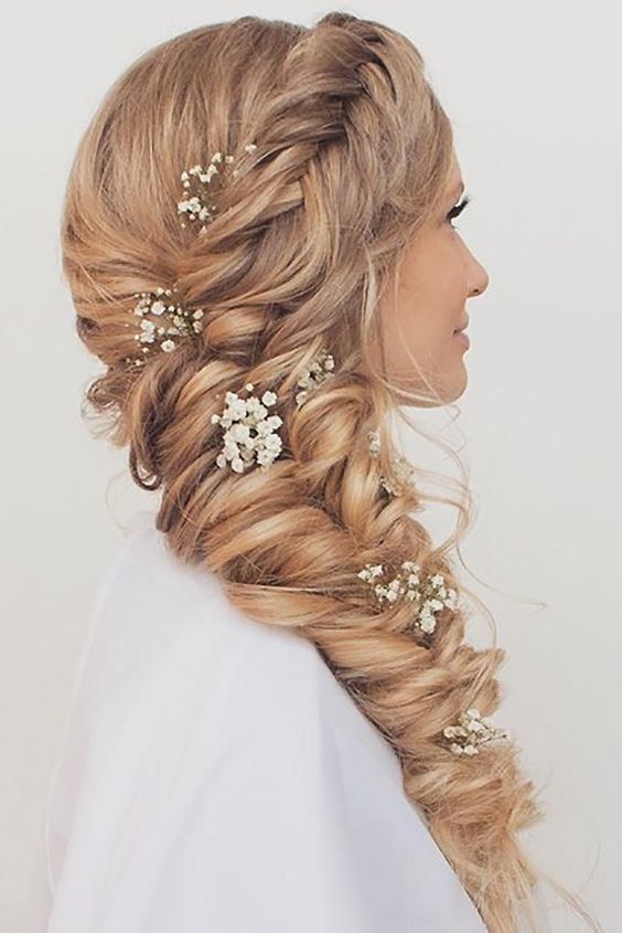 a dimensional curled blonde side braid with a side braided halo and baby's breath is a cool and chic idea for a boho or rustic wedding