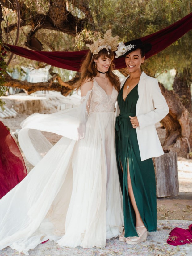 a flowy wedding dress with a lace bodice and beading, a gold crown with pearls, a green wedding dress with a white blazer, a black hat with white blooms