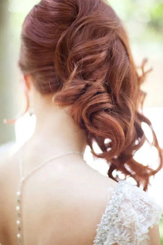 a gorgeous ginger side-swept wavy hairstyle with face-framing locks is a fantastic idea for a wedding