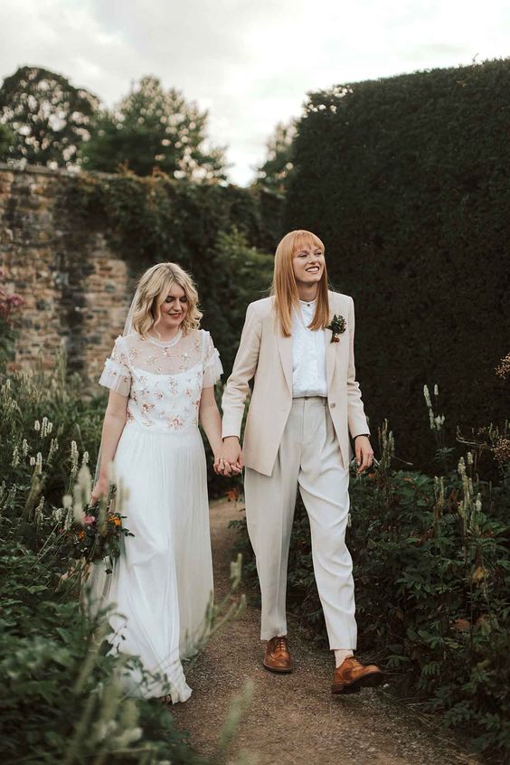 a neutral pantsuit with an oversized blazer, white shirt, brown shoes, an off the shoulder wedding dress with a pink embroidery cover up