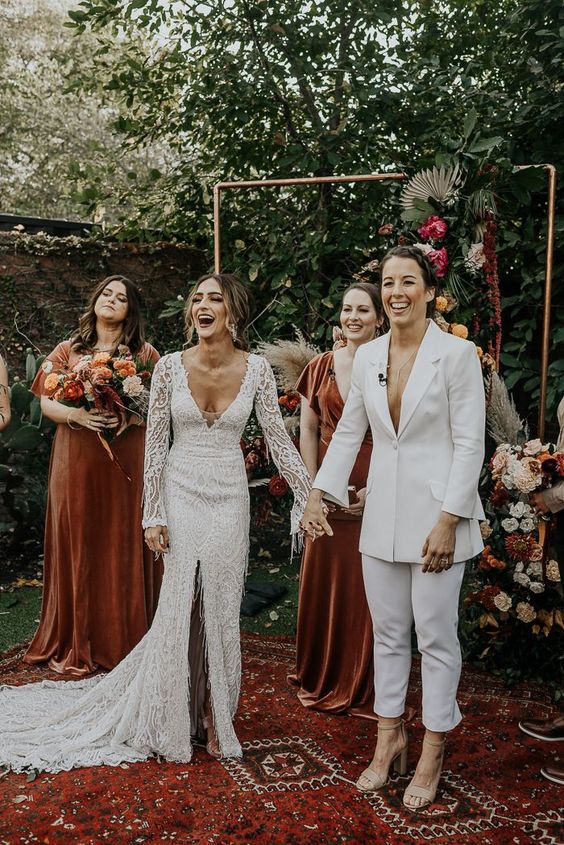 a plain modern white pantsuit with cropped panes and nude shoes, a boho lace mermaid wedding dress with a front slit and a train