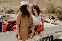 a plain sleeveless midi wedding dress paired with black boots, white pants, a beige overiszed shirt and boots plus a hat for a desert boho wedding