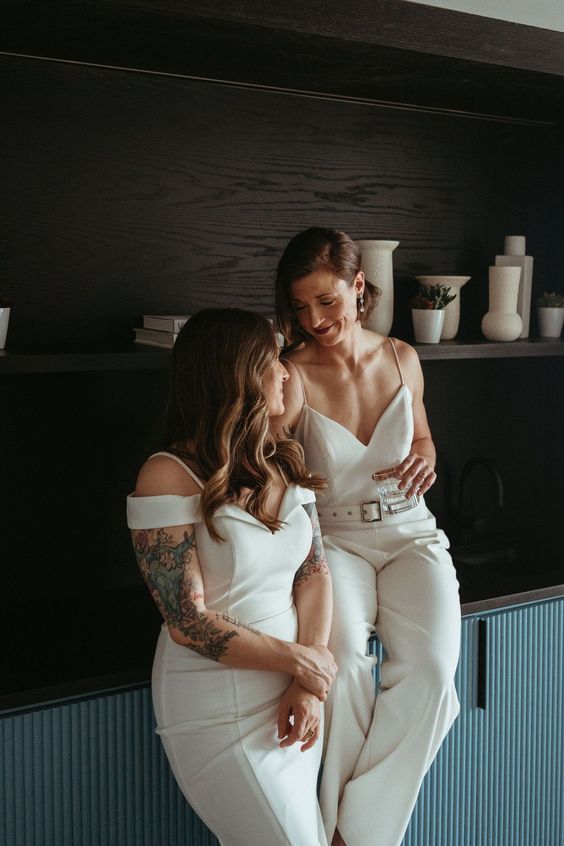 a plain white jumpsuit with a V-neckline and a belt, a plain off the shoulder wedding dress create a super stylish modern combo