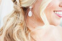 a pretty and easy blonde knot side pnytail and waves framing the face are a simple and cool idea for a wedding