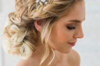 a romantic braided side chignong with several braids on top, some waves down and a crystal hairpiece