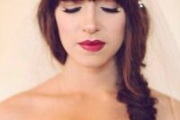 a side fishtail braid with a classic fringe and a rhinestone hairpiece with a veil are a gorgeous and cool and chic combo