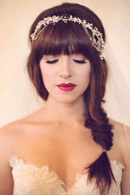 a side fishtail braid with a classic fringe and a rhinestone hairpiece with a veil are a gorgeous and cool and chic combo