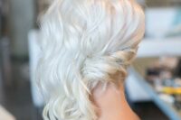 a simple and lovely platinum blonde side swept wavy updo is a chic idea, add red lips and go