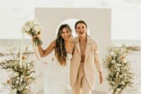 an oversized tan pantsuit, white sneakers, an off the shoulder plain wedding dress with a front slit for a beach wedding