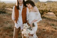 boho bridal looks with a white shirt, an orange waistcoat, tan pants, brown shoes, an off the shoulder lace mermaid wedding dress with a train