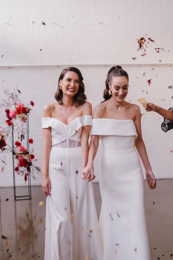 modern bridal looks, one with an off the shoulder plain mermaid wedding dress, the second with an off the shoulder jumpsuit with wideleg pants