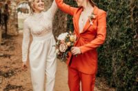 the first bride in a rust-colored pantsuit with white platform shoes and a hat, the second bride wearing a jumpsuit with a lace bodice and plain pants